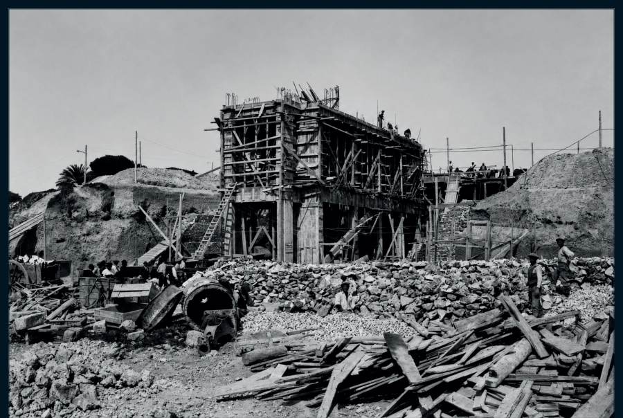 Die Baustelle in vollem Betrieb, zwischen Steinhaufen und Schalungsholz.